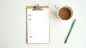A clipboard checklist with a pen and a cup of coffee